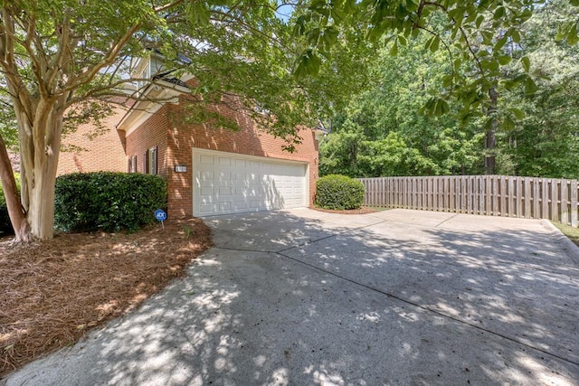 4589 Carnoustie Ln, Columbus, GA 31909 - view of side of home with brick siding, driveway, fence, and a garage