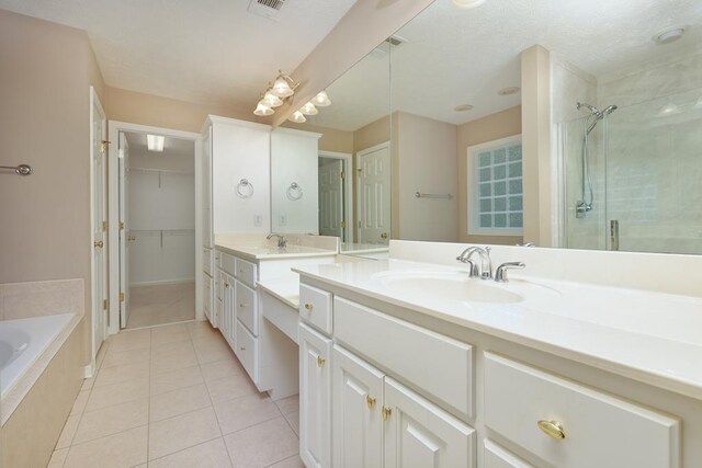 4589 Carnoustie Ln, Columbus, GA 31909 - full bathroom with a shower stall, tile patterned floors, double vanity, a bath, and a spacious closet