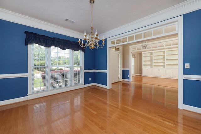 4589 Carnoustie Ln, Columbus, GA 31909 - empty room with a chandelier, crown molding, baseboards, a textured ceiling, and wood finished floors