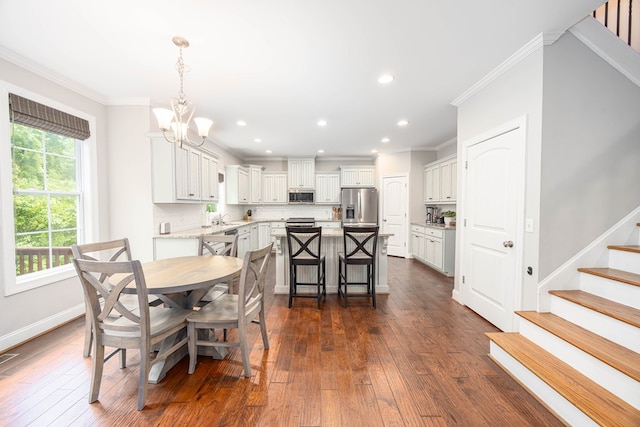 6027 Wellesley Dr, Columbus, GA 31904 - dining room featuring ornamental molding, stairway, a chandelier, dark wood-type flooring, and recessed lighting