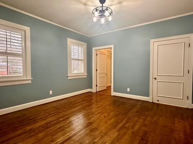 unfurnished bedroom featuring dark wood-type flooring, an inviting chandelier, ornamental molding, and multiple windows