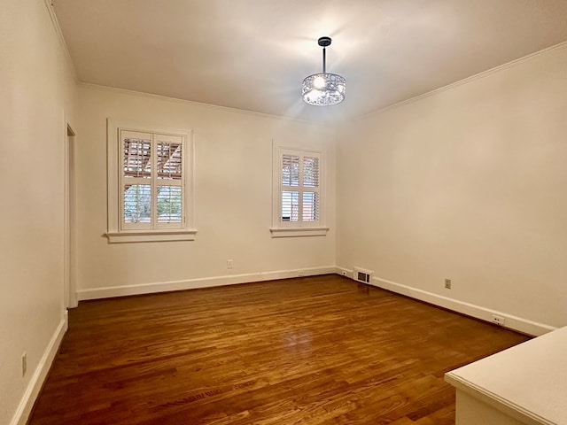 spare room featuring dark hardwood / wood-style floors, a wealth of natural light, and ornamental molding