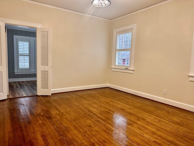 empty room featuring crown molding and hardwood / wood-style flooring