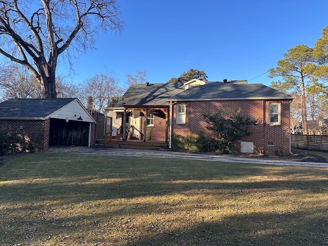 back of property featuring an outdoor structure, a yard, and a garage