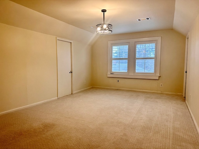 bonus room featuring lofted ceiling, a notable chandelier, and carpet flooring