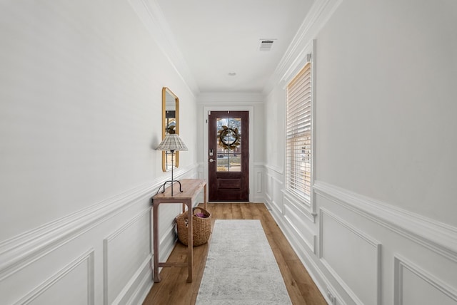 doorway featuring ornamental molding and light hardwood / wood-style floors