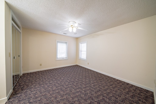 5604 Holland Dr, Columbus, GA 31909 - unfurnished bedroom with a textured ceiling, baseboards, dark carpet, and a ceiling fan