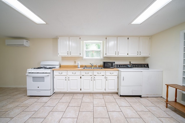 5604 Holland Dr, Columbus, GA 31909 - kitchen featuring white gas range, black microwave, a wall unit AC, washing machine and clothes dryer, and a sink