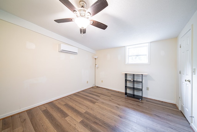 5604 Holland Dr, Columbus, GA 31909 - below grade area featuring an AC wall unit, wood finished floors, ceiling fan, baseboards, and a textured ceiling