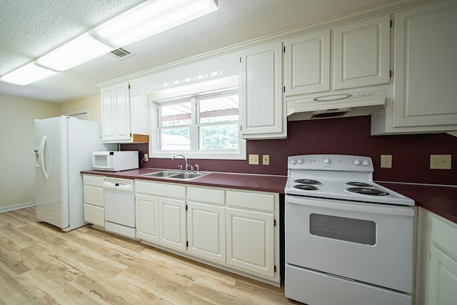 5604 Holland Dr, Columbus, GA 31909 - kitchen with white appliances, a sink, under cabinet range hood, dark countertops, and light wood-type flooring