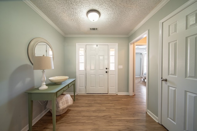 foyer with hardwood / wood-style floors, crown molding, and a textured ceiling