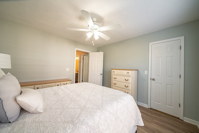 bedroom with hardwood / wood-style flooring, ceiling fan, and a textured ceiling