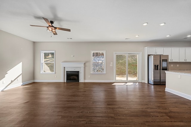 unfurnished living room with ceiling fan and dark hardwood / wood-style floors