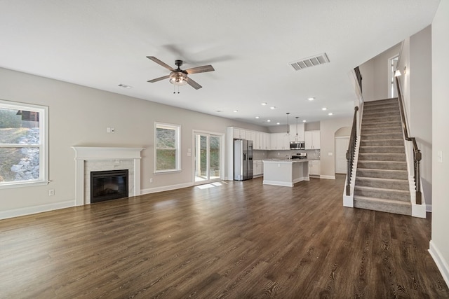 unfurnished living room featuring ceiling fan and dark hardwood / wood-style floors