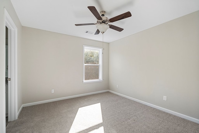 empty room featuring ceiling fan and carpet