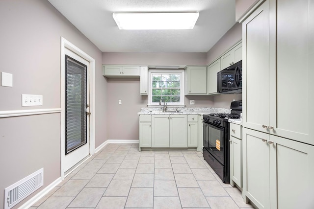 5906 Forrest Rd, Columbus, GA 31907 - kitchen with black appliances, light countertops, and light tile patterned floors