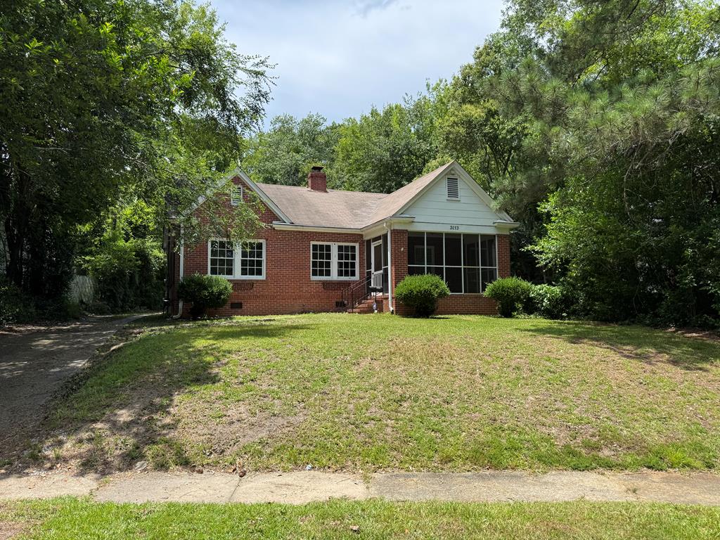 3013 18th Ave, Columbus, GA 31901 - view of front of house with brick siding, a sunroom, a front lawn, a chimney, and crawl space