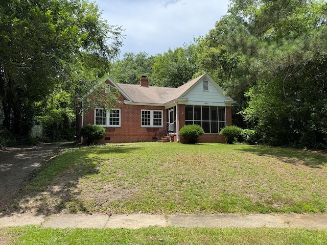 3013 18th Ave, Columbus, GA 31901 - view of front of house with brick siding, a sunroom, a front lawn, a chimney, and crawl space