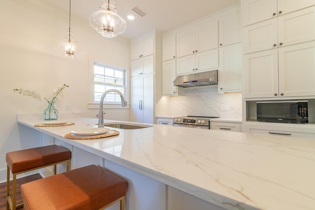 kitchen featuring sink, light stone countertops, and a kitchen bar