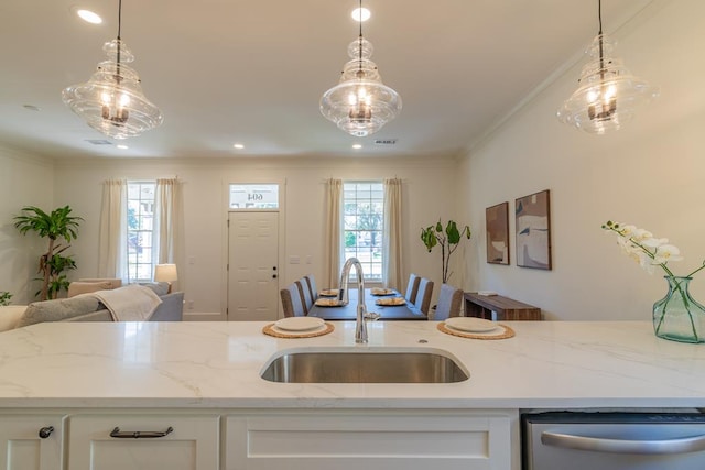 kitchen featuring white cabinetry, sink, stainless steel dishwasher, and light stone countertops