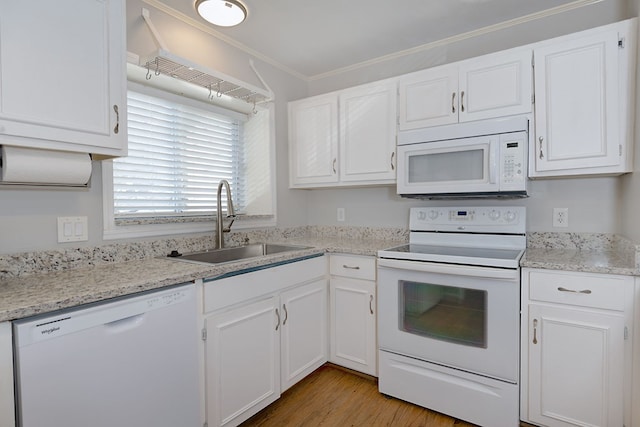 kitchen featuring white appliances, a sink, white cabinets, and crown molding