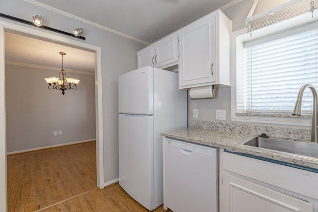 kitchen with white appliances, crown molding, white cabinetry, and a sink