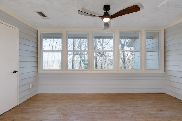 unfurnished sunroom featuring ceiling fan and visible vents