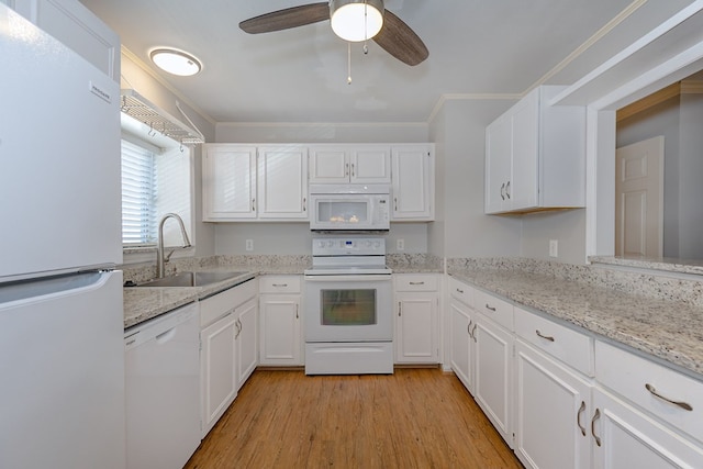 kitchen featuring white appliances, light wood finished floors, crown molding, white cabinetry, and a sink