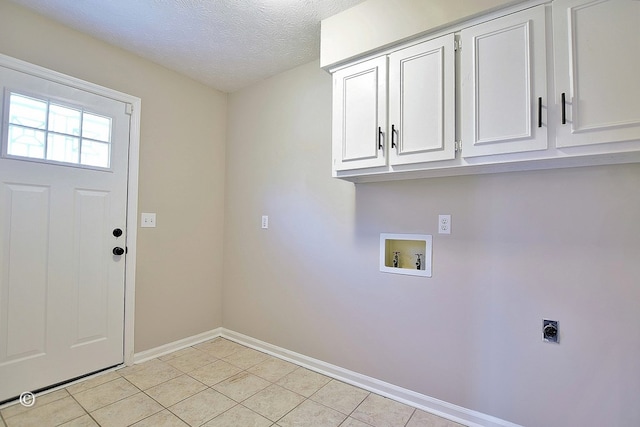 washroom with a textured ceiling, cabinet space, light tile patterned floors, hookup for an electric dryer, and hookup for a washing machine