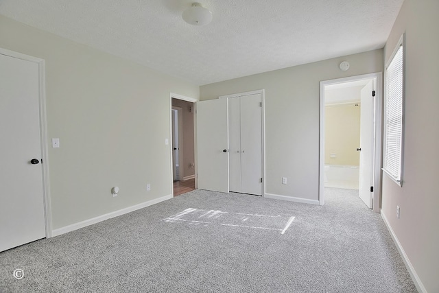 unfurnished bedroom featuring baseboards, a textured ceiling, and carpet