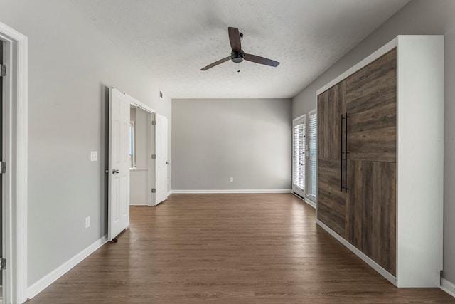 7310 Westport Loop, Midland, GA 31820 - unfurnished bedroom with a textured ceiling, dark wood-style flooring, baseboards, and a ceiling fan