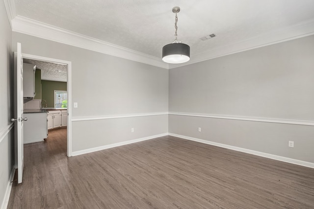 7310 Westport Loop, Midland, GA 31820 - spare room featuring crown molding, a textured ceiling, dark wood-type flooring, and baseboards