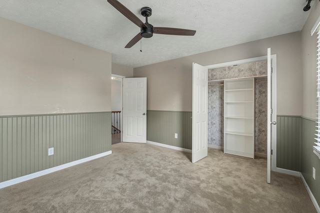 7310 Westport Loop, Midland, GA 31820 - unfurnished bedroom featuring a textured ceiling, carpet floors, a closet, a wainscoted wall, and a ceiling fan