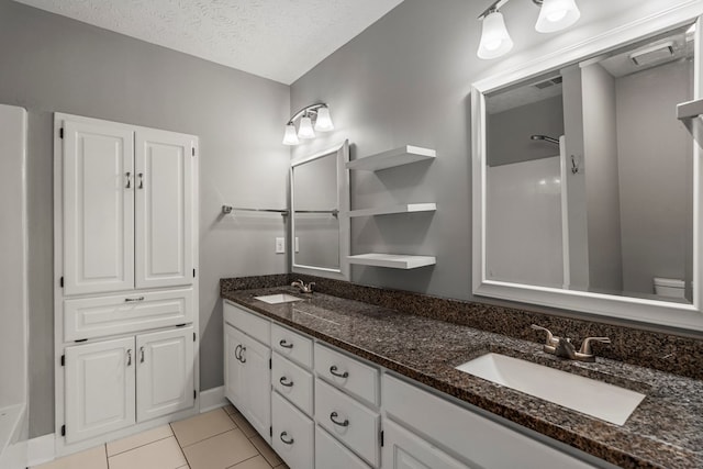 7310 Westport Loop, Midland, GA 31820 - full bathroom with double vanity, tile patterned flooring, a textured ceiling, baseboards, and a shower