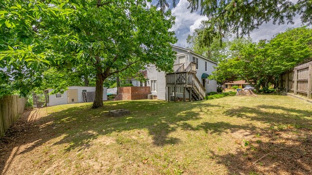 view of yard with stairway, an outbuilding, and a wooden deck