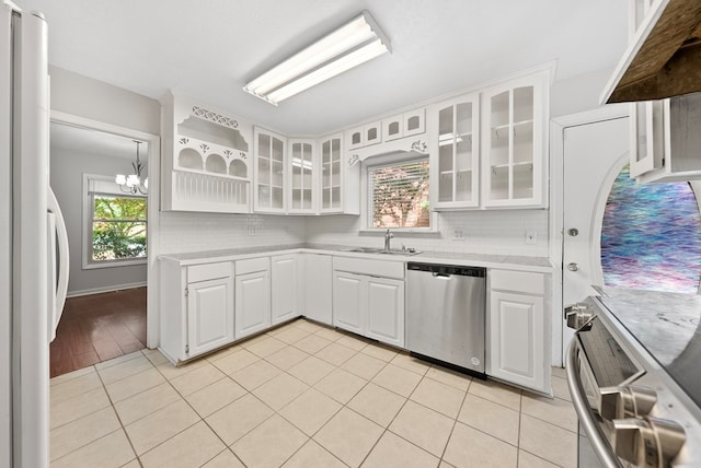 kitchen with stainless steel dishwasher, a sink, refrigerator, light countertops, and stove