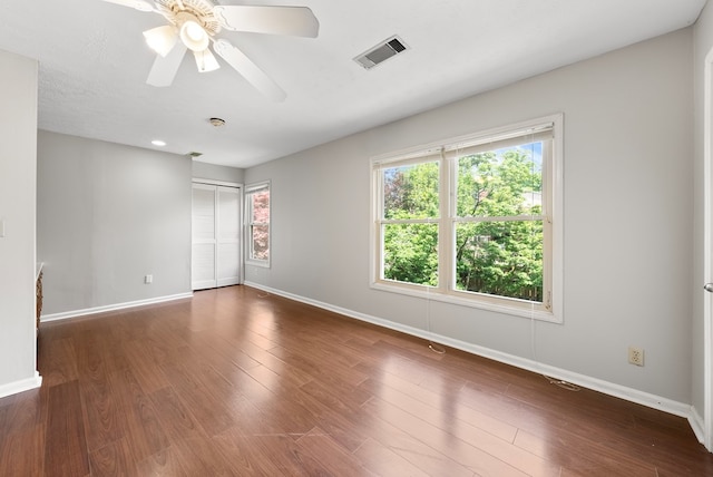 spare room with baseboards and wood finished floors