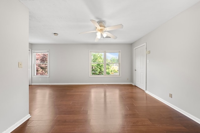 empty room featuring a ceiling fan, healthy amount of natural light, and baseboards