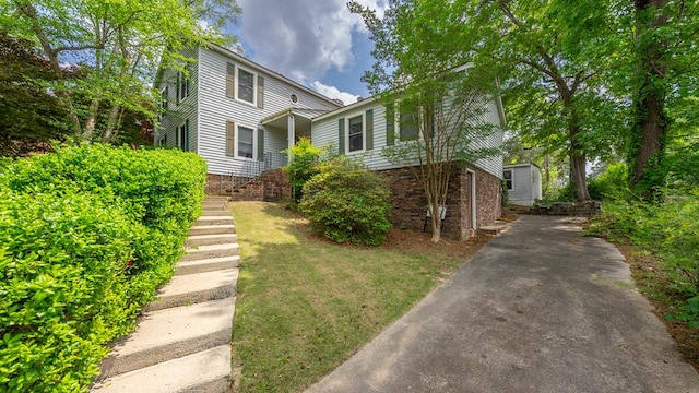 view of front of property featuring concrete driveway, stairway, and brick siding
