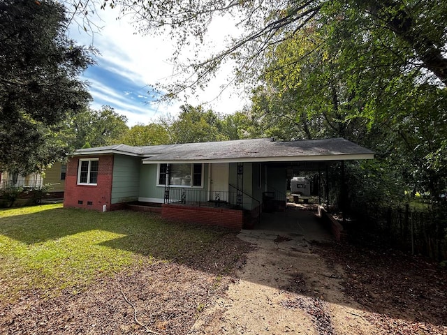 ranch-style home featuring a porch, a front yard, and a carport