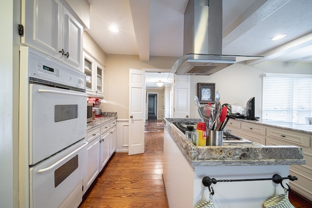 6130 Bristol Blvd, Columbus, GA 31904 - kitchen with island range hood, double oven, wood finished floors, recessed lighting, and light stone countertops