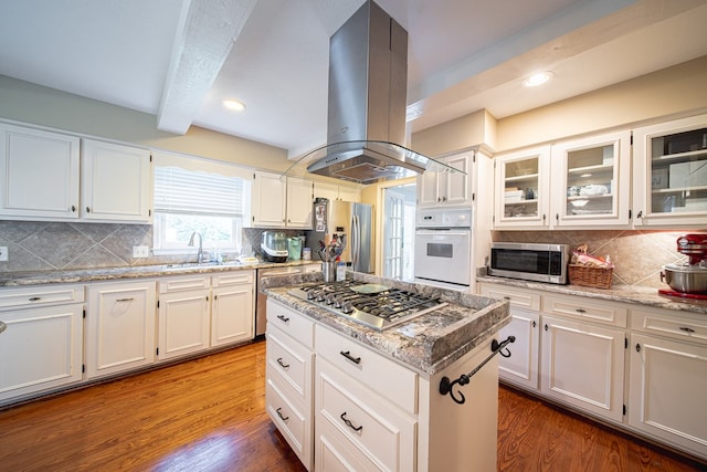 6130 Bristol Blvd, Columbus, GA 31904 - kitchen featuring stainless steel appliances, island exhaust hood, beamed ceiling, decorative backsplash, and wood finished floors