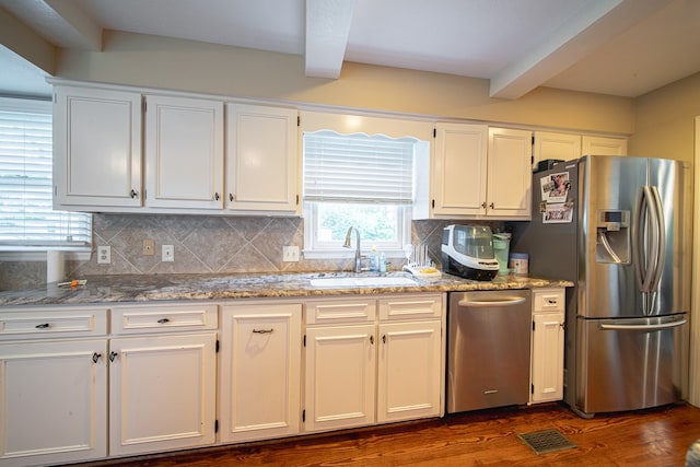 6130 Bristol Blvd, Columbus, GA 31904 - kitchen featuring stainless steel appliances, beamed ceiling, dark wood-style flooring, tasteful backsplash, and white cabinetry