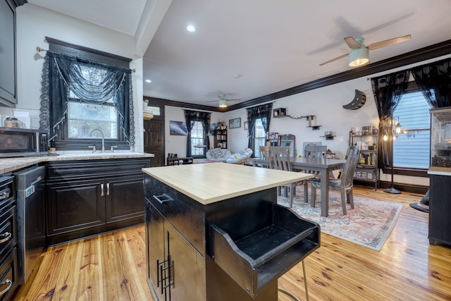 kitchen with ceiling fan, light wood finished floors, appliances with stainless steel finishes, and ornamental molding