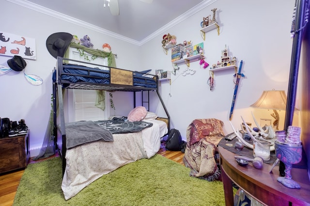 bedroom featuring ceiling fan, ornamental molding, and wood finished floors