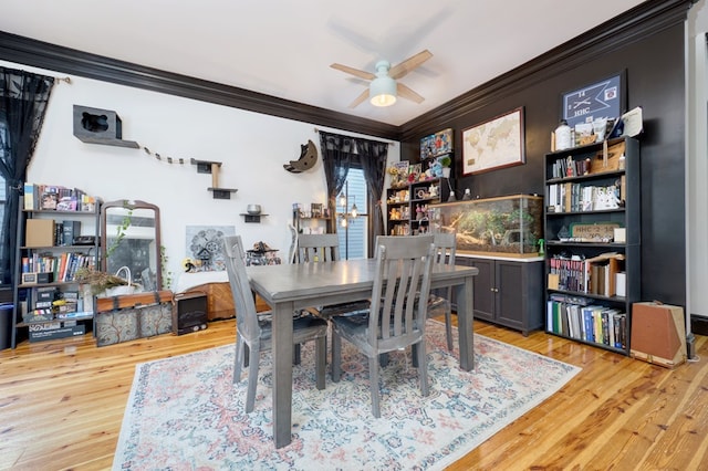 dining space featuring ornamental molding, wood finished floors, and a ceiling fan