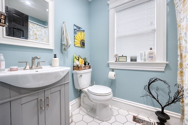 full bath featuring toilet, vanity, visible vents, and baseboards