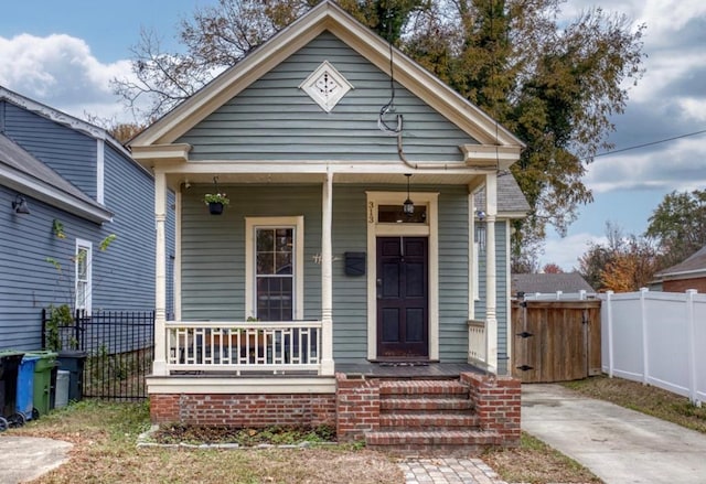 view of front of home with covered porch and fence