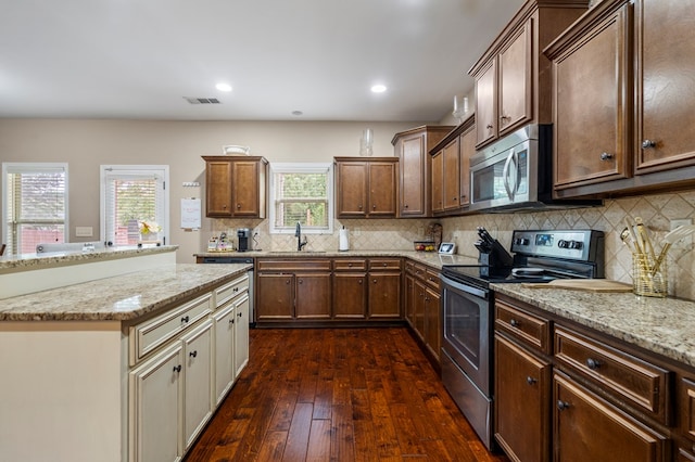51 New Castle Dr, Phenix City, AL 36870 - kitchen with appliances with stainless steel finishes, dark wood-style floors, backsplash, light stone countertops, and recessed lighting