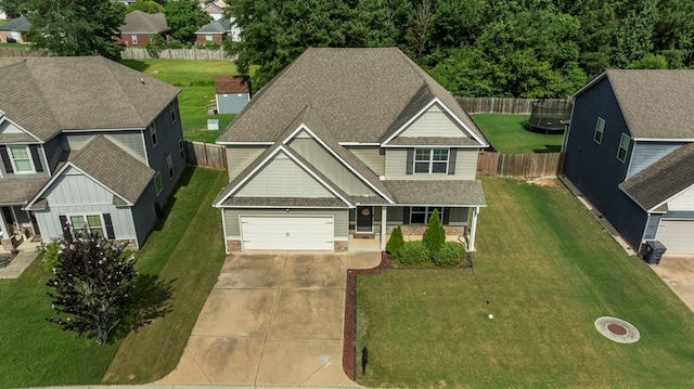 51 New Castle Dr, Phenix City, AL 36870 - view of front of home featuring concrete driveway, a trampoline, covered porch, roof with shingles, and stone siding
